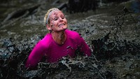 Lihat saja wanita ini, dengan gigihnya melewati medan sungai berlumpur yang berat. Perlombaan lintas alam ini memang terbuka baik untuk pria maupun wanita, dari semua golongan umur (Jonathan Nackstrand/Getty Images)
