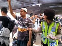 Polwan dan Kowad membagikan air dan permen ke massa (Foto: Meilika/detikcom)