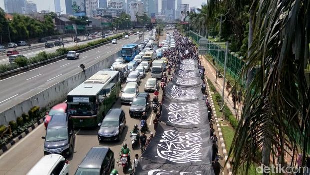 Massa datang dengan membentangkan bendera, satu lajur jalan terpakai