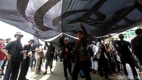 Massa dari Alumni 212 ikut beraksi menolak Perppu Ormas di depan gedung DPR/MPR. Mereka melakukan long march dan membentangkan bendera Ar-Rayah.