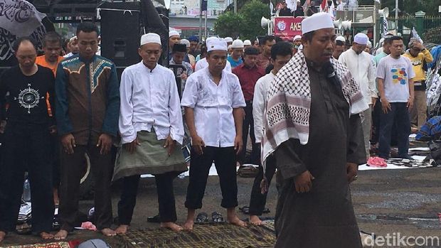 Massa laki-laki salat di depan gerbang gedung DPR/MPR