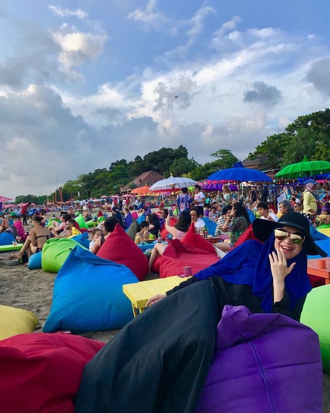 Ketika pergi ke pantai, Silvana Herman mengenakan gamis panjang hitam dan kerudung syari. Floppy hat hitam dan kacamata berukuran besar menjadi aksesori yang pas saat dipakai ke pantai. Foto: Dok. Instagram @silvanahermanreal_ano