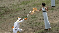 Api kemudian dinyalakan ke obor yang untuk kali pertama dibawa oleh peski asal Yunani, Apostolos Angelis. (Milos Bicanski/Getty Images)