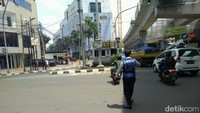 Petugas menjaga lokasi uji coba sistem satu arah sambil melakukan sosialisasi.