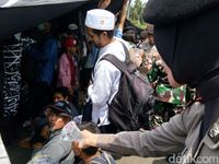 Polwan dan Kowad membagikan air dan permen ke massa (Foto: Meilika/detikcom)