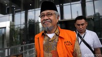 Nur Alam berjalan meninggalkan gedung KPK sambil melempat senyuman.