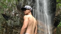 Ada pula saat ia wisata ke air terjun. Verrell berpose di depan air terjun sambil bertelanjang dada (bramastavrl/Instagram)