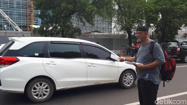 Massa membagikan selebaran kepada pengguna jalan yang melintas di depan Kedubes AS