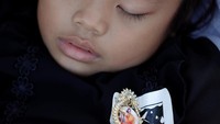 Seorang anak perempuan tampak terlelap saat menunggu prosesi kremasi.