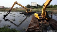 Ekskavator melakukan pengerukan.