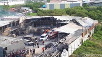 Mobil pemadam kebakaran dan ambulans bersiaga di area pabrik.