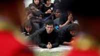 Ratusan ribu warga Thailand yang berpakaian serba hitam duduk sambil bersujud di tepi jalan. Foto: REUTERS/Damir Sagolj