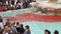 Turis tampak mengelilingi air mancur Trevi yang mendadak berubah jadi merah. Air mancur ini memang merupakan lokasi wisata yang populer. (Foto: INSTAGRAM / @ELESADVENTURE / www.elesadventure.com /via REUTERS)