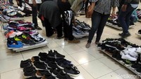 Pengunjung memilih sepatu-sepatu yang didiskon.