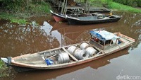 Pengangkutan material listrik dengan kapal kayu melintasi sungai di Indragiri Hilir untuk dibawa ke desa-desa yang belum berlistrik. Pool/PLN Wilayah Riau dan Kepri.