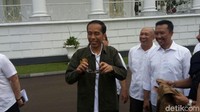 Jokowi lalu memakainya dan tersenyum lebar.  