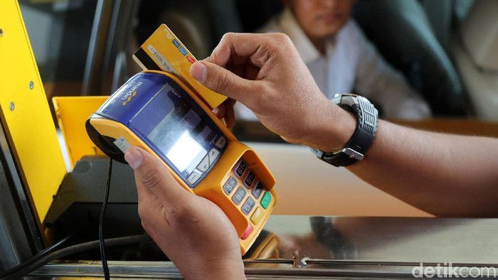 Petugas melayani pengendara untuk melakukan pengisian e-money di Pintu Tol Meruya Utara 3, Jakarta, Jumat (27/10/2017). Pengendara hanya cukup lapor kepada petugas untuk melakukan pengisian e-money, lalu petugas akan membantu untuk melakukan pengisian. Grandyos Zafna/detikcom