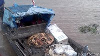 Pengangkutan material listrik dengan kapal kayu melintasi sungai di Indragiri Hilir untuk dibawa ke desa-desa. Pool/PLN Wilayah Riau dan Kepri.