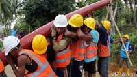 Gotong-royong menegakkan tiang listrik di desa Sungai Ara, Indragiri Hilir. Pool/PLN Wilayah Riau dan Kepri.