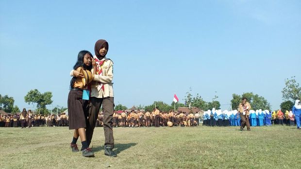 Siswa yang tidak kuat mengikuti upacara, dipapah ke pinggir lapangan