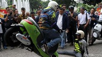 Pengendara motor listrik melakukan aksi freestyle di halaman Balai Kota.