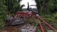 Pengangkutan tiang listrik dari Pelabuhan Tembilahan ke desa di Kecamatan Pelanghiran, Indragiri Hilir, Riau, melewati parit di sekitar kebun sawit. Pool/PLN Wilayah Riau dan Kepri.