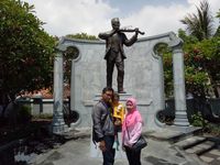 Titik dan suaminya berpose berlatar belakang patung WR Soepratman