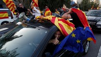 Para pendemo mengibarkan bendera Uni Eropa, Spanyol, dan Catalonia sembari mengendarai mobilnya di Barcelona, Spanyol (REUTERS/Yves Herman)