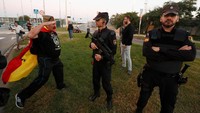 Seorang pendemo melakukan gerakan hormat ke arah anggota kepolisian nasional Spanyol (REUTERS/Yves Herman)