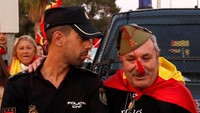 Seorang pendemo yang menolak kemerdekaan Catalonia berpose dengan seorang anggota kepolisian Spanyol untuk menunjukkan solidaritas (REUTERS/Yves Herman)