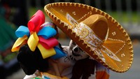 Sepasang pria dan wanita ikut parade Kematian dengan berdandan ala Catrina dan Catrin, dua karakter Mexico yang juga dikenal dengan nama “The Elegant Death”. Foto: Edgard Garrido/Reuters