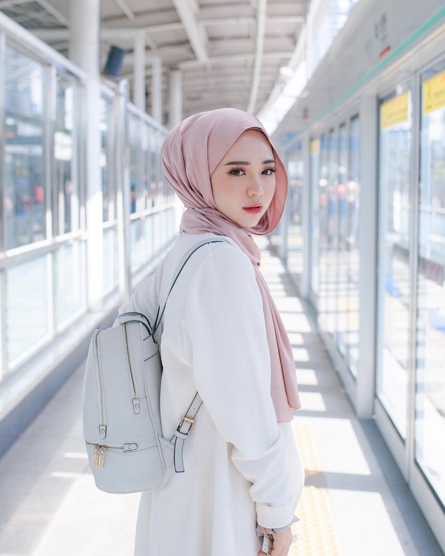 Gaya hijab kasual saat traveling ala Adira Salahudi ini cocok bagi pecinta style yang simpel. Perpaduan hijab biru muda dan setelan putih memberikan tampilan yang segar. Foto: Dok. Instagram @adirasalahudi