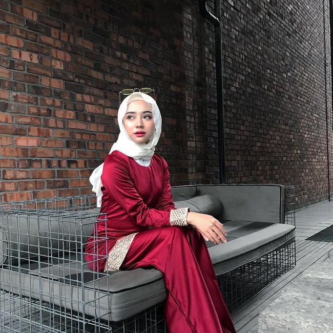 Gaya Adira Salahudi yang satu ini cocok untuk pergi kondangan. Pilihan setelan rok dan blouse satin merah marun serta kerudung putih menimbulkan kesan anggun. Foto: Dok. Instagram @adirasalahudi