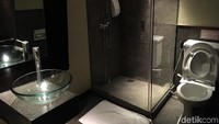 Di kamar itu, ada toilet dan shower yang hanya dibatasi tirai dengan kasur.