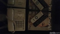 Telepon dan remote TV diletakkan di samping kasur.