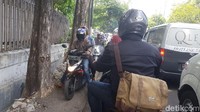 Jangankan mobil, motor pun kesulitan untuk maju akibat bertumpuknya kendaraan. Dengan terpaksa, pengendara motor ini menerabas dengan menaiki trotoar.