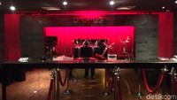 Di sebelah kiri, ada tulisan CASHIER. Kursi-kursi tampak diletakkan terbalik di area itu.