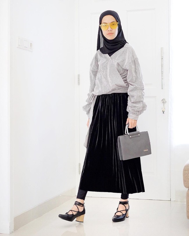Gaya selebgram Iymel akan membuat penampilan lebih eksentrik. Konsep monokrom dalam perpaduan blouse modifikasi serta rok lipit velvet membuat penampilan terlihat beda. Gaya hijab ini juga cocok direfleksikan untuk ke kantor. Foto: Dok. Instagram