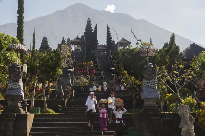 Umat Hindu membawa sesajen saat persembahyangan Hari Raya Galungan di tengah situasi aktifitas Gunung Agung pada level siaga di Pura Besakih, Karangasem, Bali, Rabu (1/11). Sebagian warga Besakih masih berada di pengungsian bersama warga dari lima desa lainnya karena masuk kawasan rawan bencana di radius 7,5km namun kawasan Pura Besakih telah dinyatakan aman setelah status gunung tersebut diturunkan dari awas ke siaga. ANTARA FOTO/Nyoman Budhiana/pras/17.
