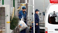 Polisi tampak membawa kantong plastik keluar dari apartemen tersebut. (Foto: Kyodo/via REUTERS)