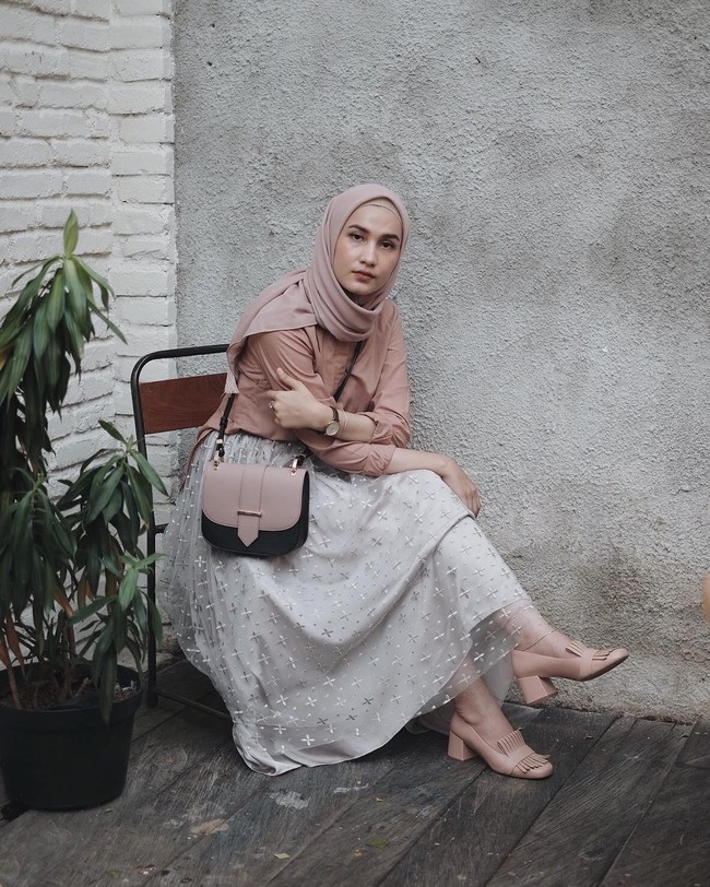 Berbusana stylish dan feminin dengan rok yang dilengkapi material transparan seperti dipakai Dwi Handayani. Perpaduan rok abu-abu dan palet dusty pink menciptakan kesan feminin. Foto: Dok. Instagram