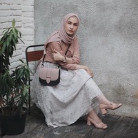 Berbusana stylish dan feminin dengan rok yang dilengkapi material transparan seperti dipakai Dwi Handayani. Perpaduan rok abu-abu dan palet dusty pink menciptakan kesan feminin. Foto: Dok. Instagram