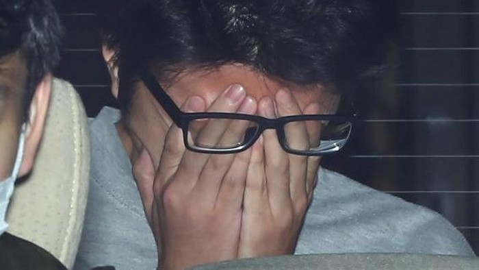 Suspect Takahiro Shiraishi covers his face with his hands as he is transported to the prosecutors office from a police station in Tokyo on November 1, 2017. 
The 27-year-old Japanese man, who was arrested after police found nine dismembered corpses rotting in his house, has confessed to killing all his victims over a two-month spree after contacting them via Twitter, media reports. / AFP PHOTO / JIJI PRESS / STR / Japan OUT
