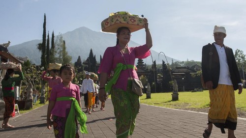 Umat Hindu membawa sesajen saat persembahyangan Hari Raya Galungan di tengah situasi aktifitas Gunung Agung pada level siaga di Pura Besakih, Karangasem, Bali, Rabu (1/11). Sebagian warga Besakih masih berada di pengungsian bersama warga dari lima desa lainnya karena masuk kawasan rawan bencana di radius 7,5km namun kawasan Pura Besakih telah dinyatakan aman setelah status gunung tersebut diturunkan dari awas ke siaga. ANTARA FOTO/Nyoman Budhiana/pras/17.