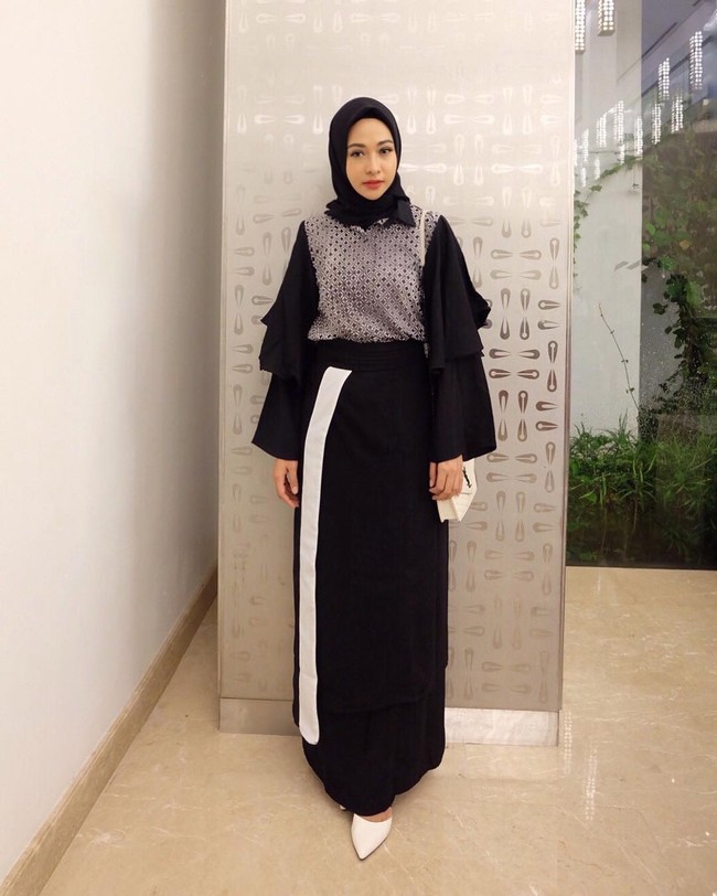 Poppy Bunga tampil cantik mengenakan high-waisted skirt berpotongan draperi dan blouse modifikasi. Sajian warna monokrom didominasi hitam tampak berani saat dikenakan ke acara formal. Poppy diketahui memakai busana rancangan Zaskia Sungkar. Foto: Dok. Instagram