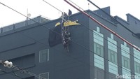 Petugas berupaya membongkar plang hotel di sisi kiri belakang gedung.