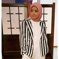 Tika Ramlan bergaya monokrom dengan padu padan kemeja putih dan striped blazer. Garis vertikal pada blazer penyanyi berdarah Bandung itu mampu memberikan ilusi tubuh ramping. Penampilan terlihat cerah dengan pemakaian kerudung merah muda. Foto: Dok. Instagram @tika_ramlan