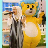 Ini momen ketika Tika Ramlan menyanyi setelah berhijab. Ia memilih jumpsuit berkancing dengan garis vertikal agar tubuhnya terlihat lebih kurus. Padu padan blouse putih, kerudung off white, dan kalung statement memberikan sentuhan yang atraktif.  Foto: Dok. Instagram @tika_ramlan