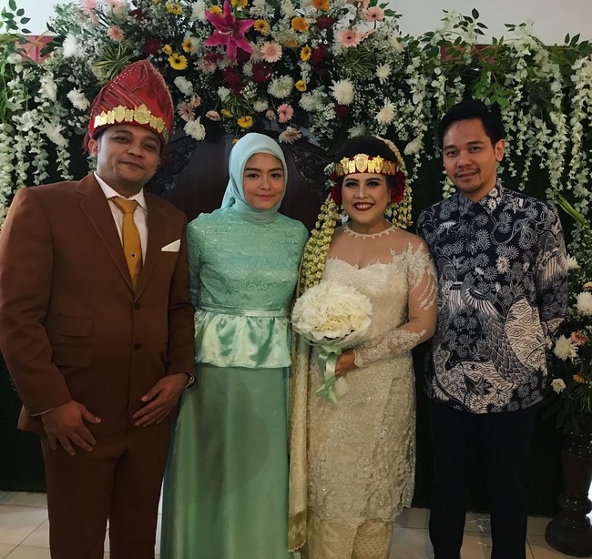 Gaya hijab Tika Ramlan saat pergi kondangan. Ia membuat baju bridesmaid warna tosca dengan potongan maxi dress yang memiliki detail ruffle di bagian tengah. Hijab simpel dengan warna senada membuat penampilan terlihat feminin.  Foto: Dok. Instagram @tika_ramlan