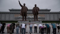 Saat berada di depan patung Kim Il Sung dan Kim Jong Il di Bukit Mansu, kamu wajib untuk menunjukkan rasa hormat. Salah satunya dengan membungkuk di depan patung. (ED JONES/AFP)